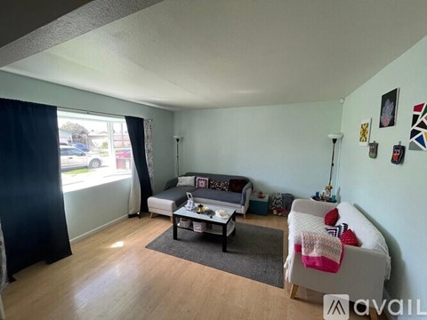 A living room with a grey sofa and a black curtain.