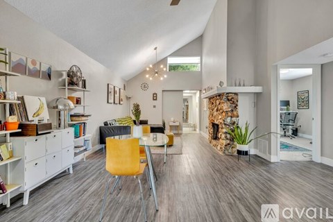 A modern living room with a yellow chair and a fireplace.