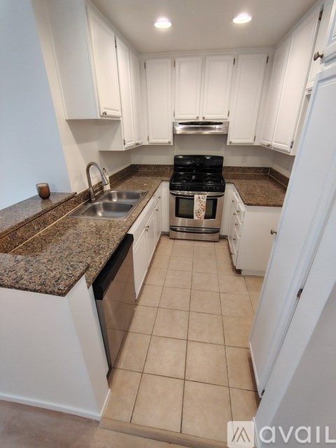 A kitchen with granite countertops and white cabinets.
