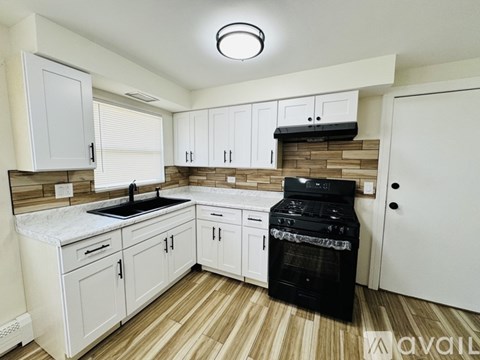 A kitchen with white cabinets and a black oven.