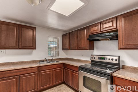 A kitchen with brown cabinets and a white stove top oven.
