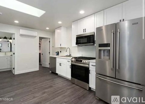 A modern kitchen with stainless steel appliances and white cabinets.