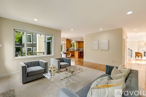 A living room with a grey couch and a glass coffee table.