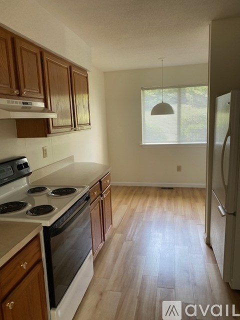 A kitchen with wooden cabinets and a stove top oven.