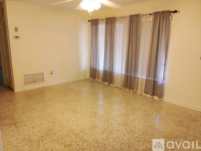 A room with a window covered by a curtain.