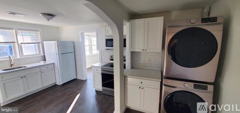 A kitchen with a washer and dryer stacked on top of each other.