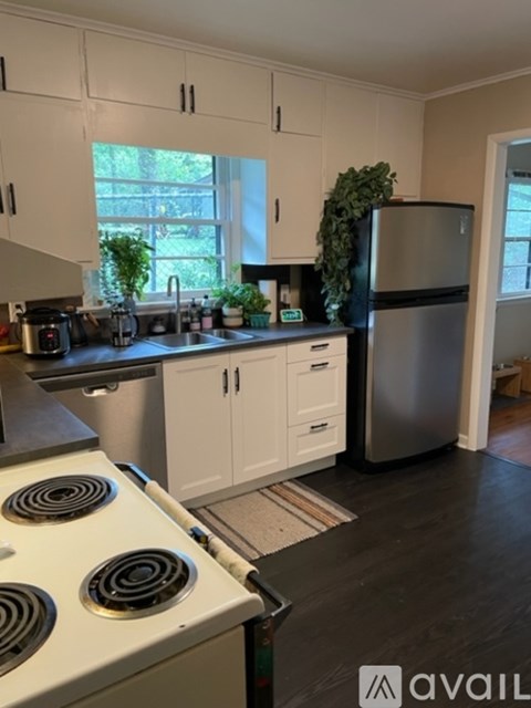 A kitchen with white cabinets and a stove top oven.