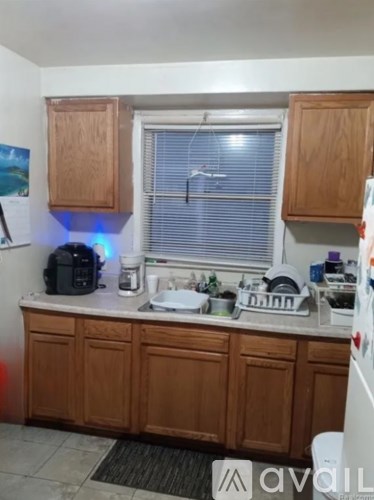 A kitchen with wooden cabinets and a white fridge.