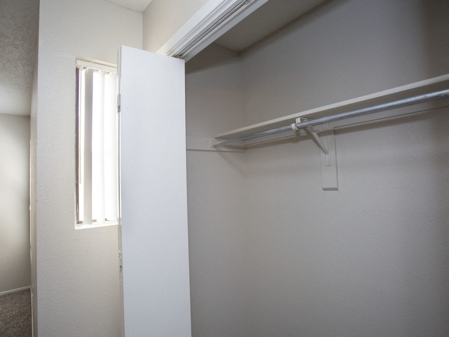 an empty closet in a room with a window