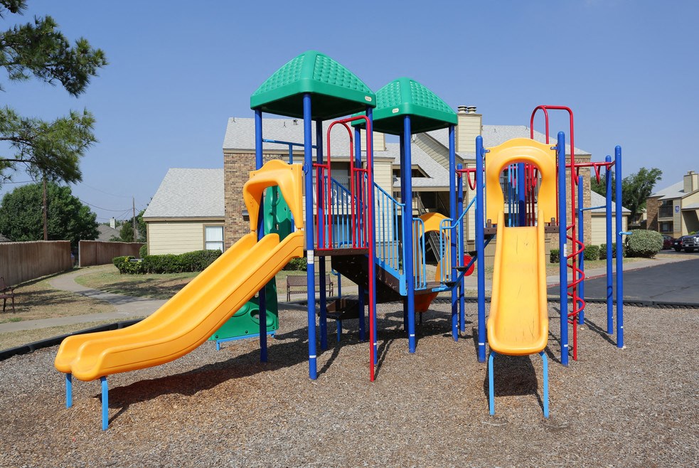 a playground with a slide and other playsets in a yard