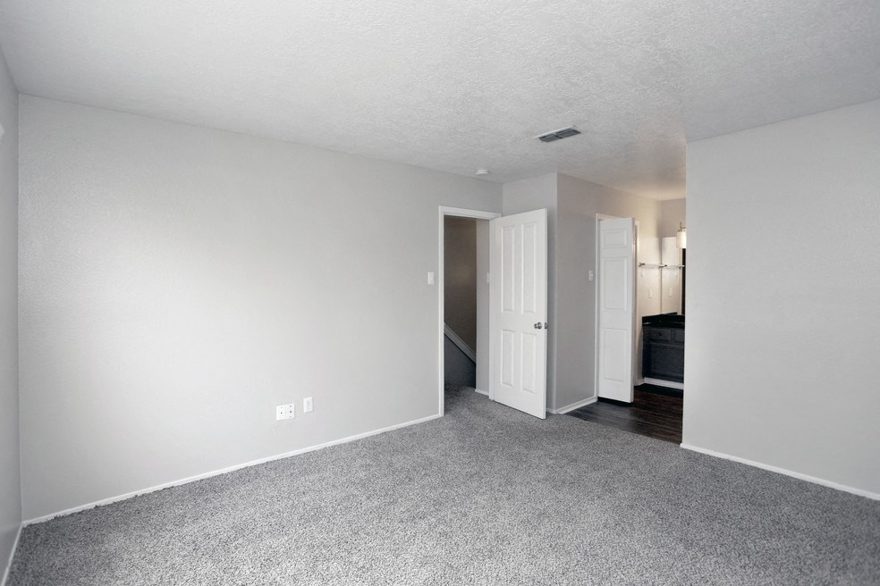 an empty living room with a white wall and carpet