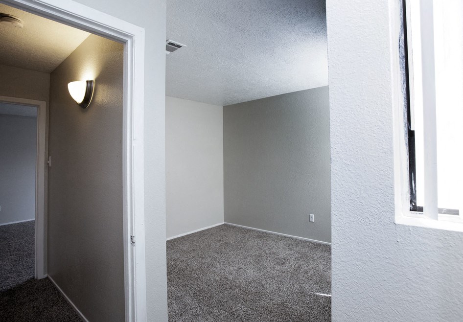 an empty room with gray walls and a window