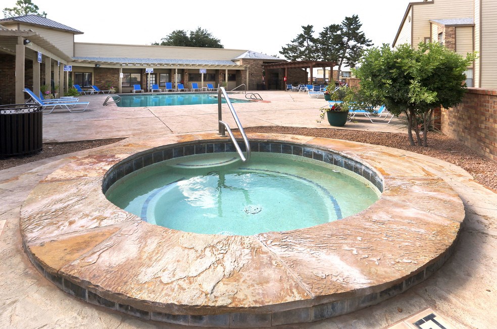 a hot tub with a fountain in the middle of a resort pool