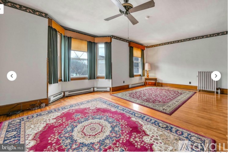 A room with a rug on the floor and a ceiling fan.