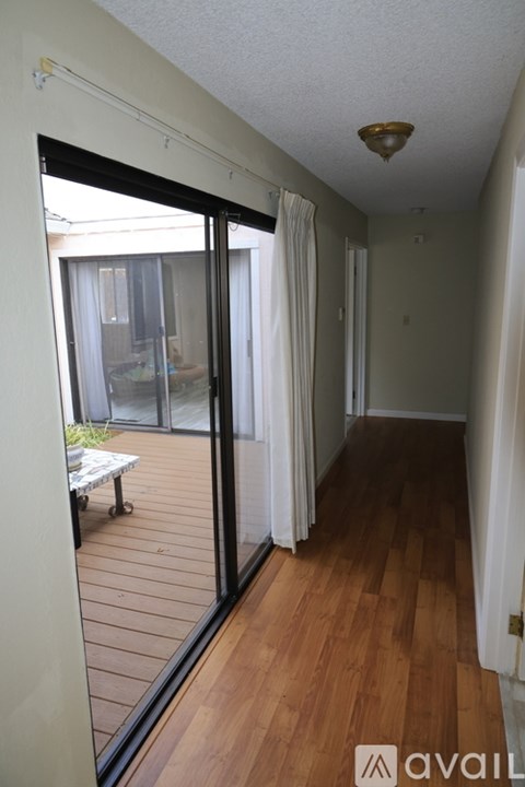 A balcony with a table and chairs is visible from the living room.
