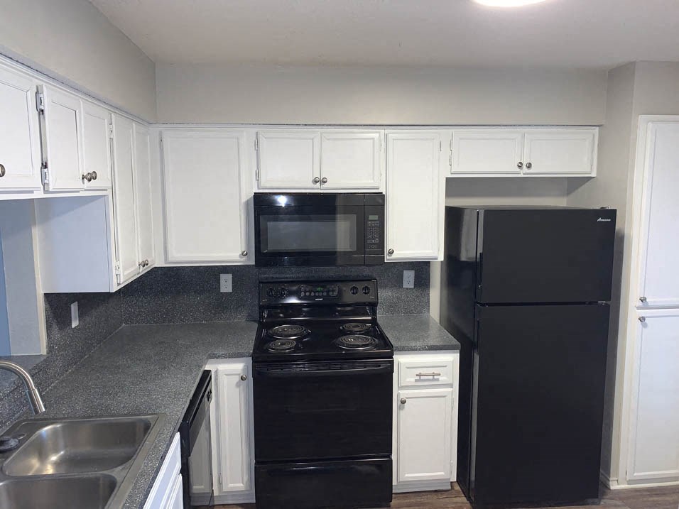 a kitchen with black appliances and white cabinets
