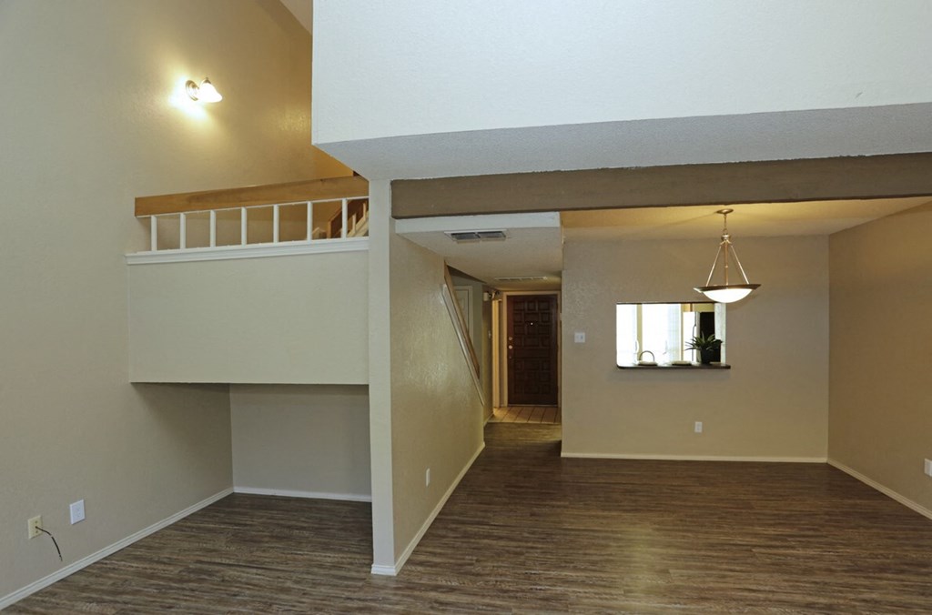 an empty living room with a staircase in a house