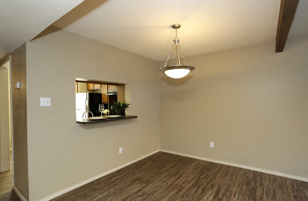 an empty living room with a ceiling fan and a mirror