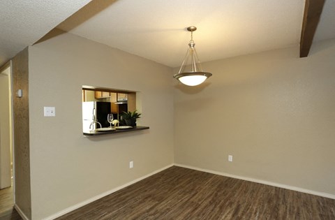 an empty living room with a ceiling fan and a mirror