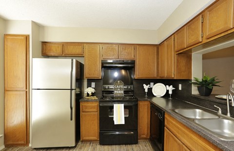 a kitchen with black appliances and wooden cabinets