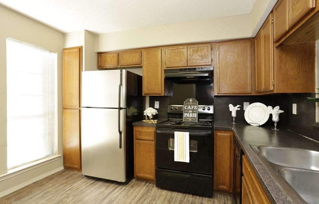 a kitchen with black appliances and wooden cabinets