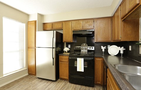 a kitchen with black appliances and wooden cabinets