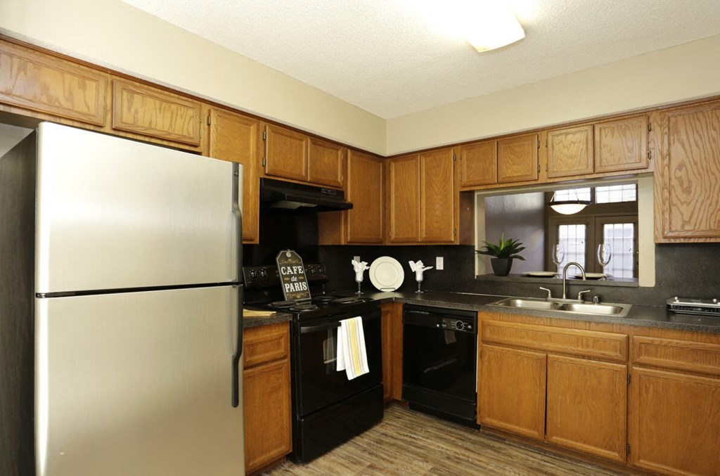 a kitchen with black appliances and wooden cabinets