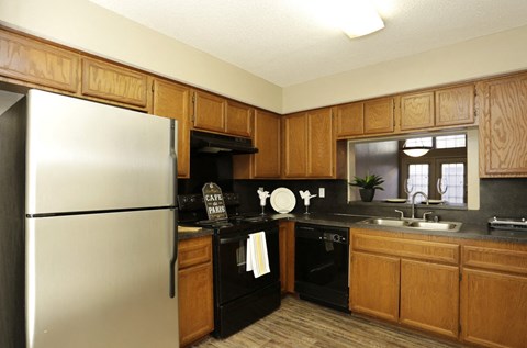 a kitchen with black appliances and wooden cabinets