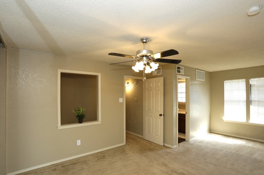 an empty living room with a ceiling fan