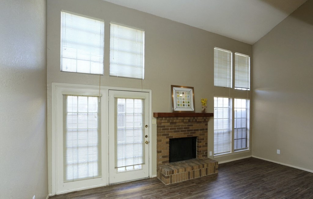 an empty living room with a fireplace and doors