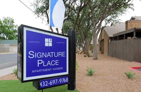 a signure place apartment homes sign in front of a house