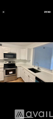 A kitchen with white cabinets and a black stove top oven.