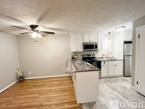 A kitchen with white cabinets and a wooden island.