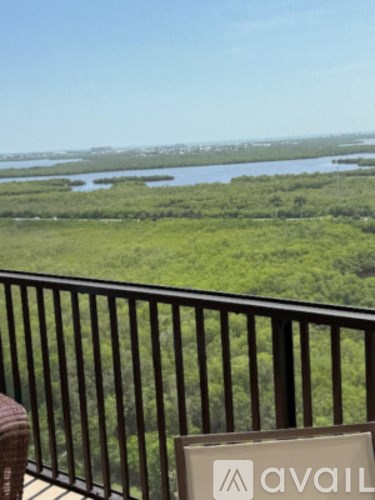 A balcony with a sign that says "avail" in front of a view of a marshy area.