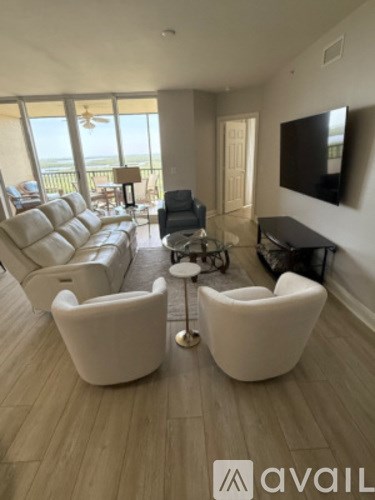 A living room with a large couch and a television on the wall.