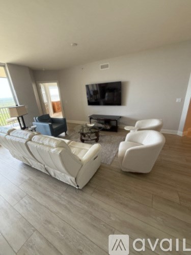 A living room with a white couch and a television.