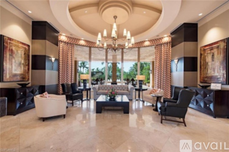 A spacious living room with a chandelier, sofas, and a coffee table.