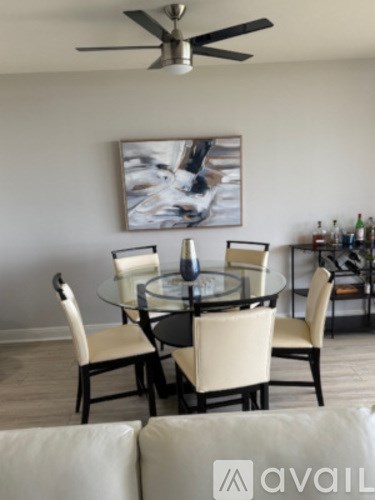 A modern dining room with a glass table and chairs.