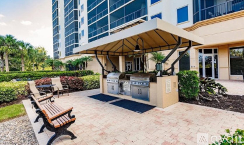 A modern building with a glass facade and a covered outdoor seating area with benches.