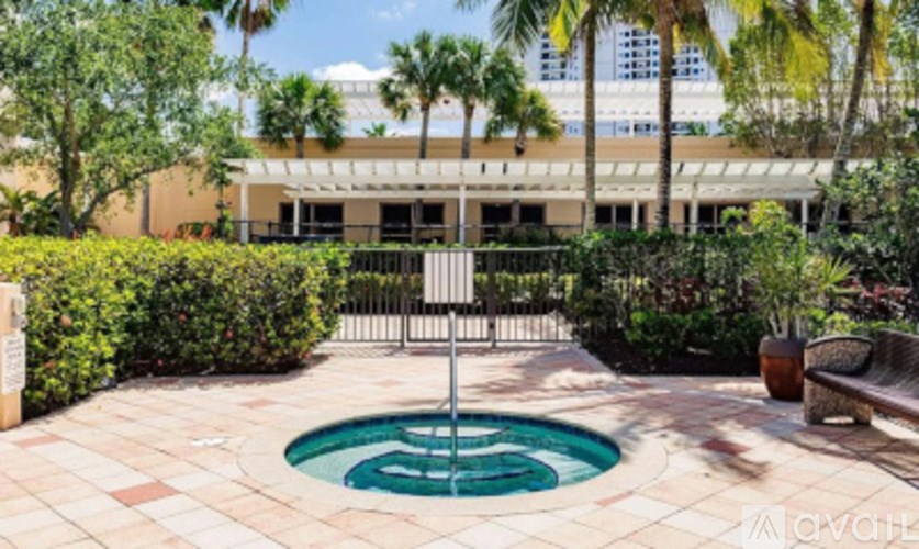 A pool surrounded by a fence and greenery.