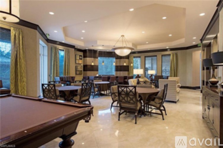 A large room with a pool table and a dining table.
