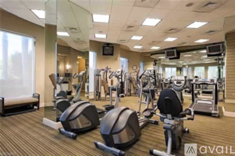 A gym with a variety of exercise equipment including treadmills, stationary bikes, and weight machines.