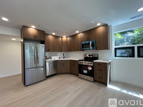 A kitchen with wooden cabinets and stainless steel appliances is available for rent.