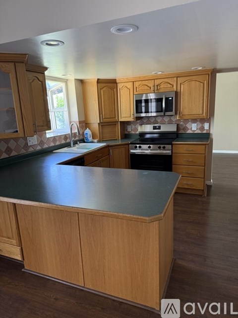 A kitchen with wooden cabinets and a black countertop.