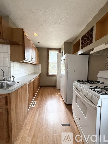A kitchen with wooden cabinets and a white stove.