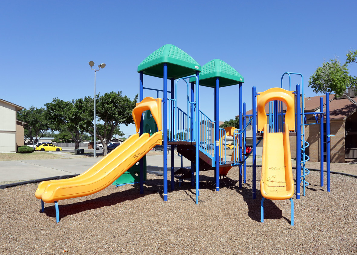 a playground with a slide and three green and yellow structures