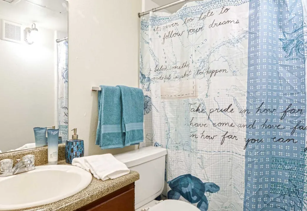 a bathroom with a shower curtain and a sink