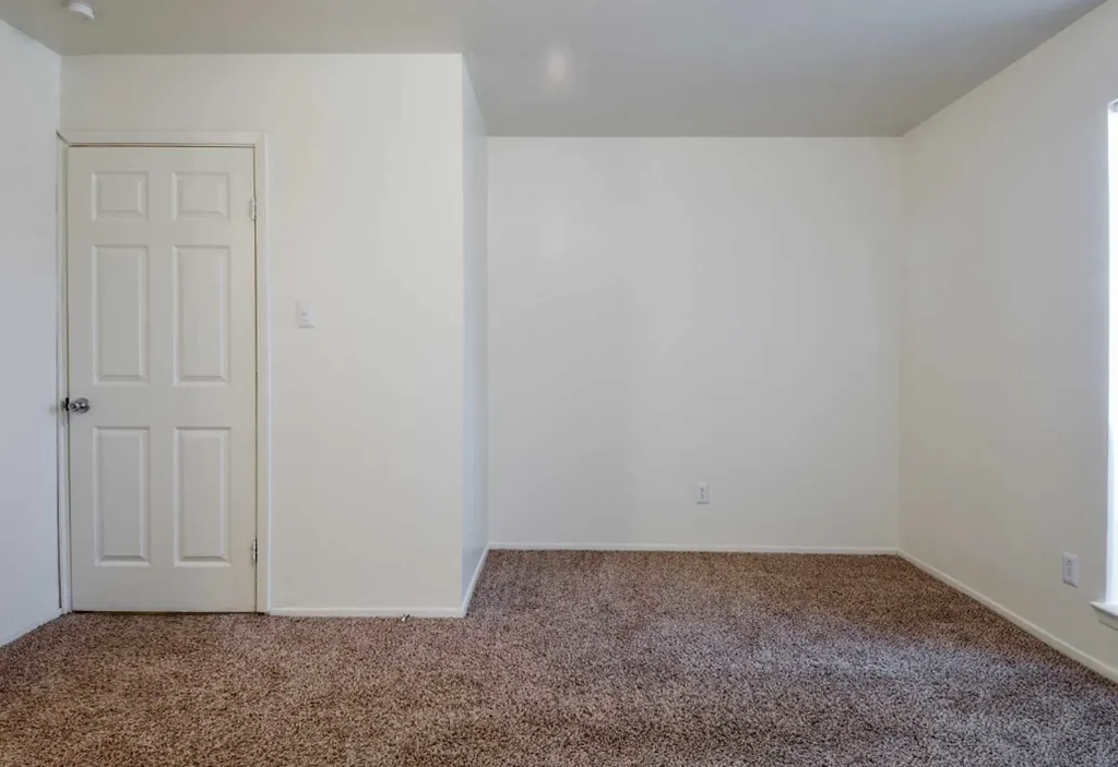 a room with a carpeted floor and a white door