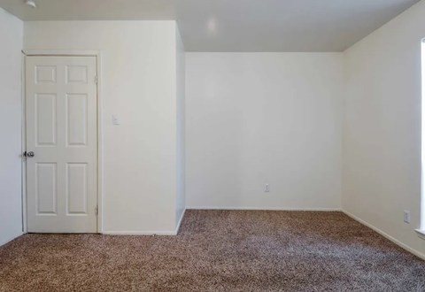 a room with a carpeted floor and a white door