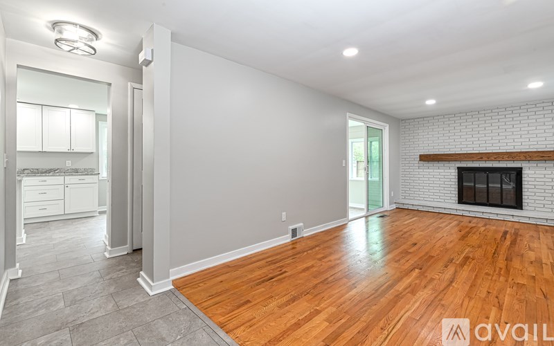 A spacious living room with a fireplace and hardwood floors.